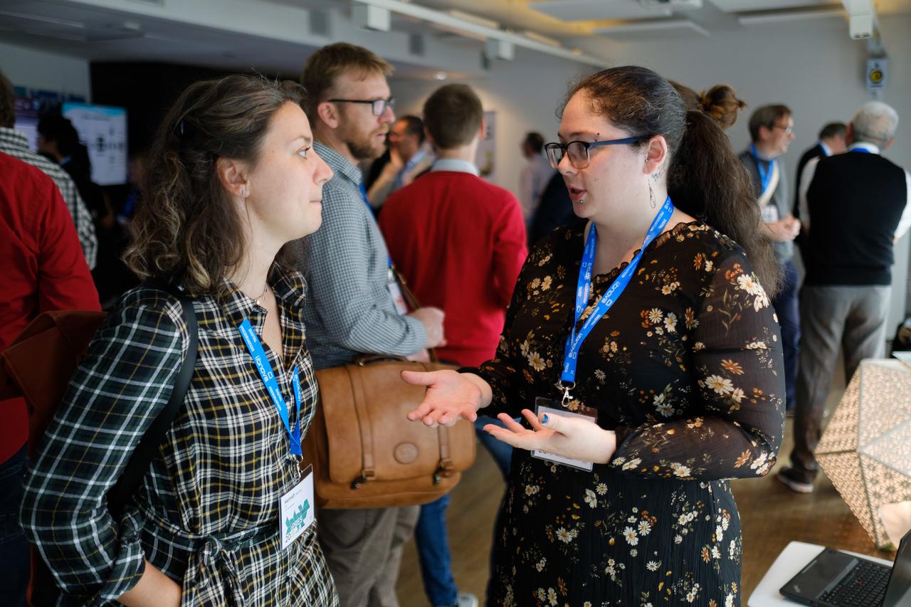 Vicky explaining the IASGE poster to a conference-goer.