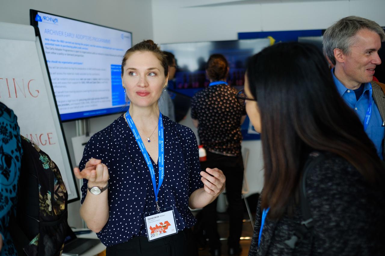 Genevieve talking to a conference-goer about our research.